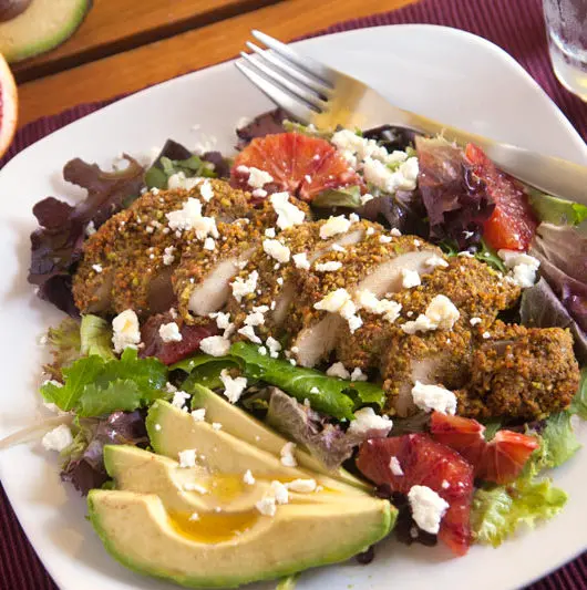 Pistachio-orange encrusted chicken salad - Pistachio-orange chicken is complemented by goat cheese, blood oranges, and avocados in this gourmet salad! | pinchmeimeating.com