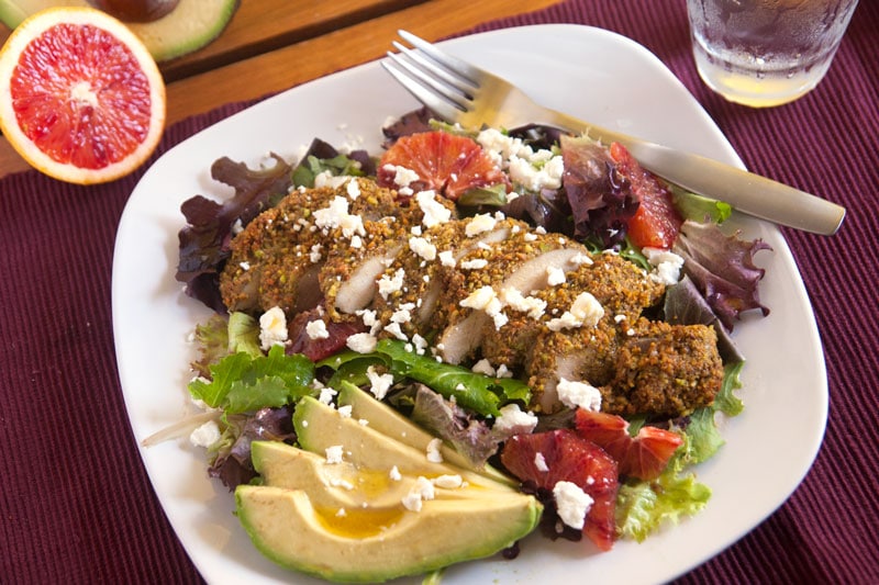 Pistachio-orange encrusted chicken salad - Pistachio-orange chicken is complemented by goat cheese, blood oranges, and avocados in this gourmet salad! | pinchmeimeating.com