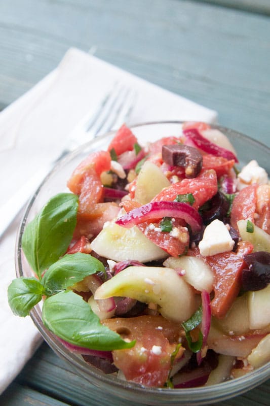 This tangy cucumber tomato salad is packed with flavor and freshness! Kalamata olives, feta cheese, and red onions add interest without stealing the show from the crisp cucumber and juicy tomatoes. | www.pinchmeimeating.com