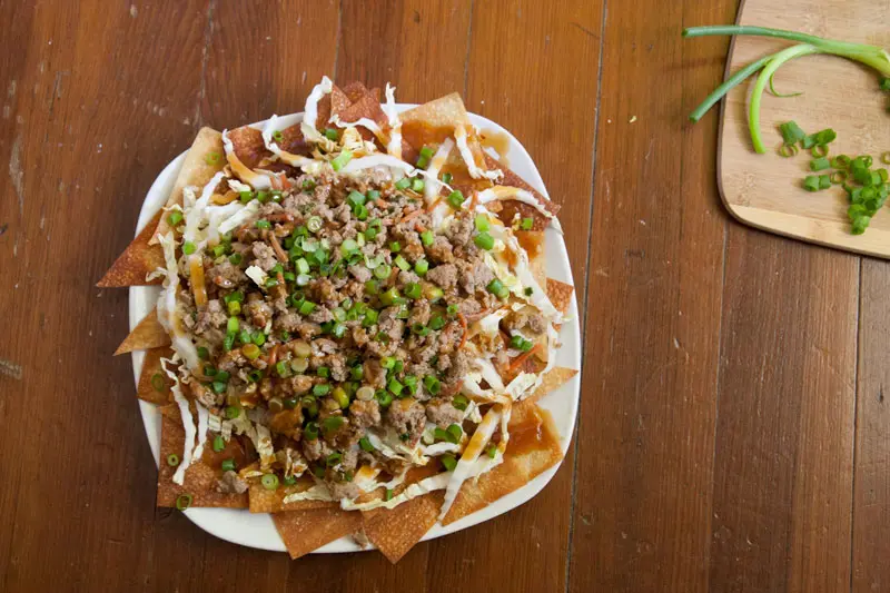 Potsticker Nachos with Baked Sesame Ginger Wonton Chips | Enjoy the juicy, gingery gyoza filling in a crunchy, fun, easy-to-share format. These Asian-inspired nachos are sure to be a hit! | www.pinchmeimeating.com