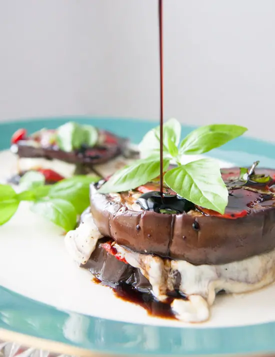 These grilled balsamic eggplant stacks are full of oh-so-melty mozzarella cheese, smoky roasted red peppers, and basil, and are perfect for a light dinner! | www.pinchmeimeating.com