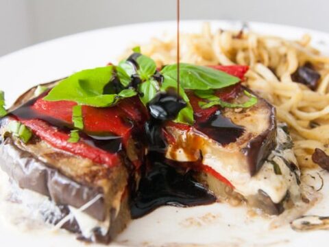Vegetarian and grain-free, these grilled balsamic eggplant stacks are full of oh-so-melty mozzarella cheese, smoky roasted red peppers, and basil, and are perfect for a light dinner! | www.pinchmeimeating.com