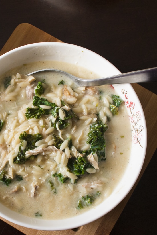Avgolemono Soup with Kale - This hearty Greek lemon chicken soup is chock full of orzo, shredded chicken, and kale and comes together in half an hour. Added eggs make the soup rich and creamy. So delicious, and I love how quick and easy it is! | www.pinchmeimeating.com