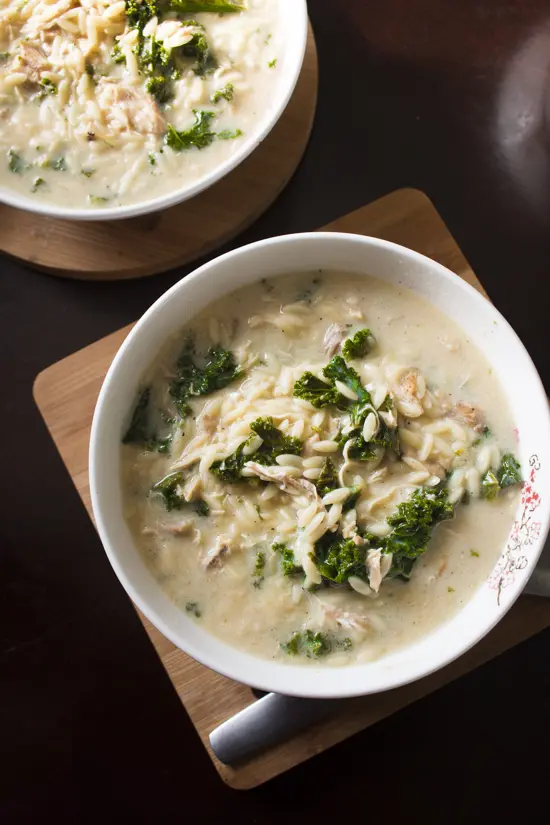 This hearty Greek lemon chicken soup is full of orzo, shredded chicken, and kale, and comes together in only 30 minutes. An easy avgolemono soup recipe! I can't believe how adding eggs to the broth makes it so creamy! Perfect for a quick and easy main course meal in the winter! | www.pinchmeimeating.com