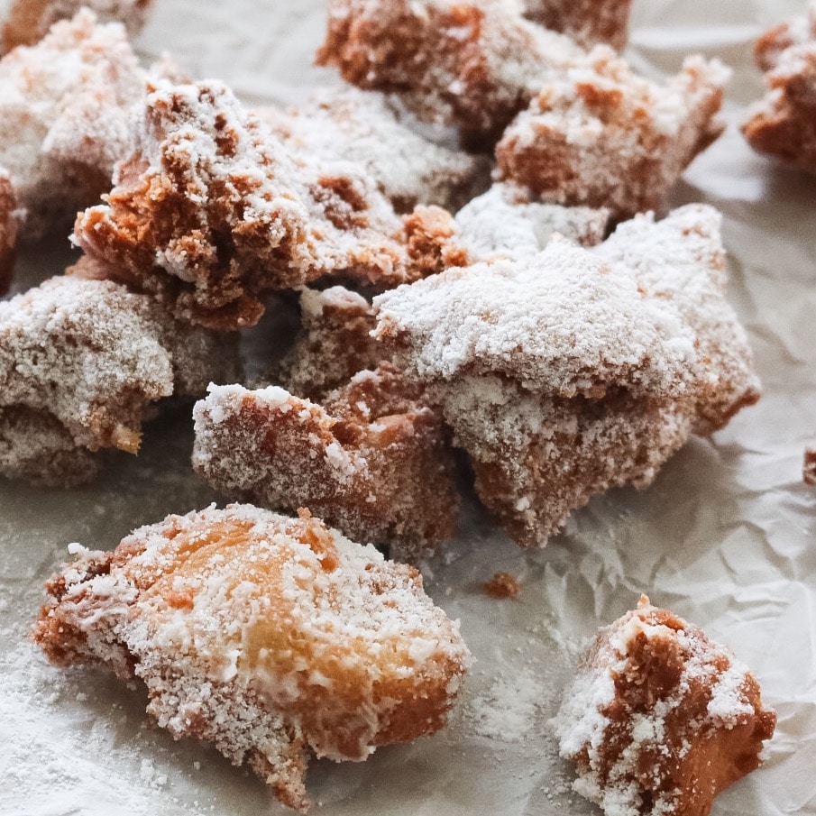 Close up of zeppole (fried Italian donuts) coated in powdered sugar