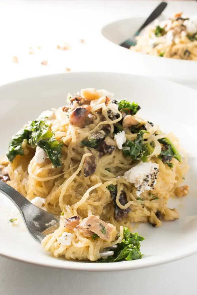 Spaghetti squash with mushrooms, walnuts, kale, and a nutmeg cream sauce is a naturally sweet, earthy dish that's simple to make, low carb, and gluten free. Great for Meatless Mondays or Meatless Fridays! There are also some great tips for the best way to cook a spaghetti squash! | www.pinchmeimeating.com