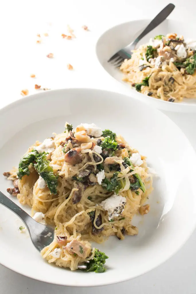 Spaghetti squash with mushrooms, walnuts, kale, and a nutmeg cream sauce is a naturally sweet, earthy dish that's simple to make, low carb, and gluten free. Great for Meatless Mondays or Meatless Fridays! There are also some great tips for the best way to cook a spaghetti squash! | www.pinchmeimeating.com