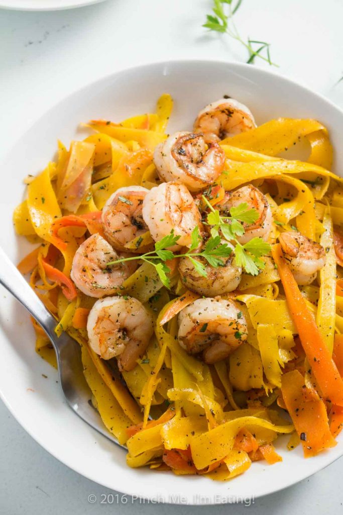 Delicate ribbons of carrots are tossed in browned butter with parsley, sage, rosemary, and thyme and topped with shrimp to make a fresh, flavorful, beautiful, and healthy meal. Carrot noodles are paleo and gluten free too! | www.pinchmeimeating.com