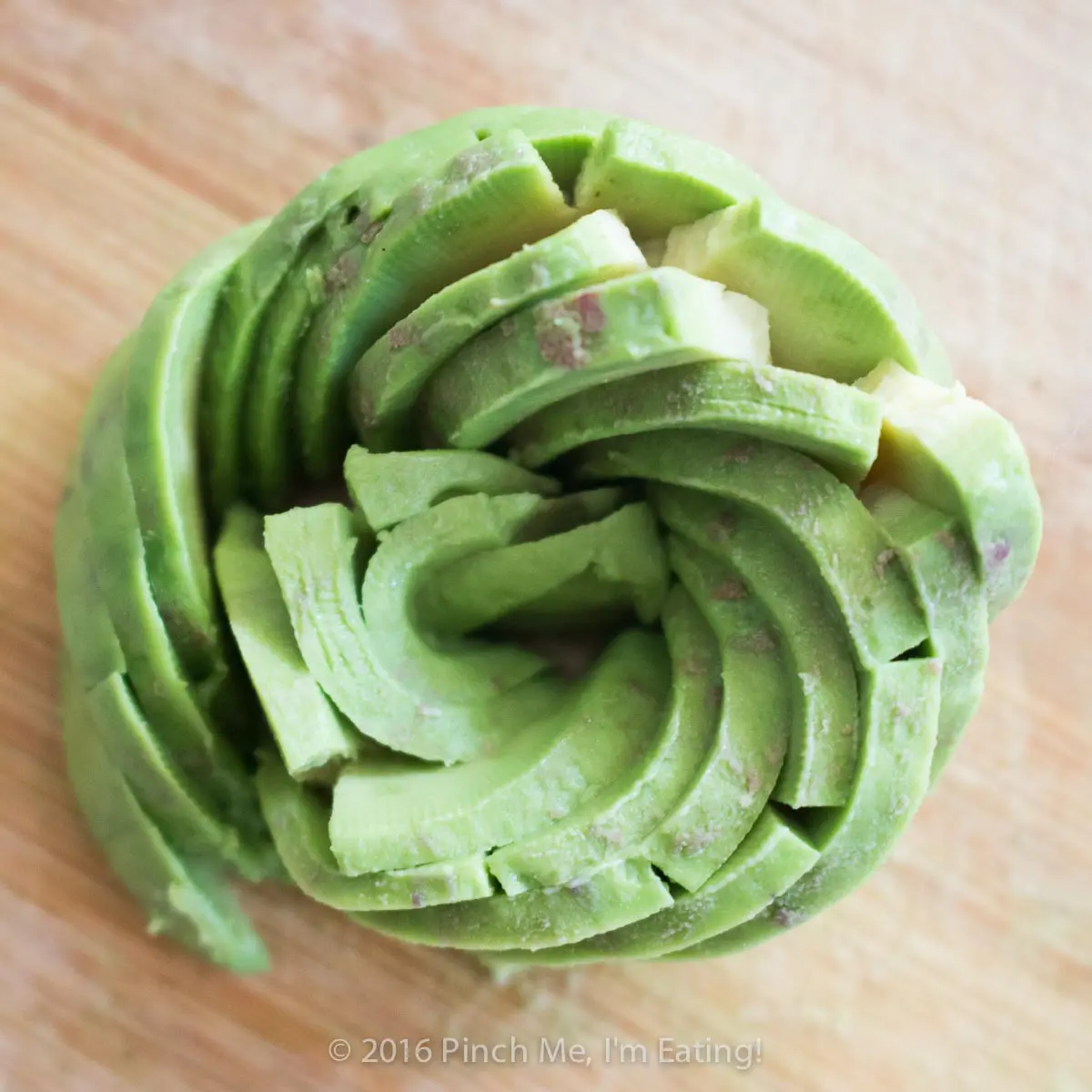 An edible rose made from spiraled avocado slices.