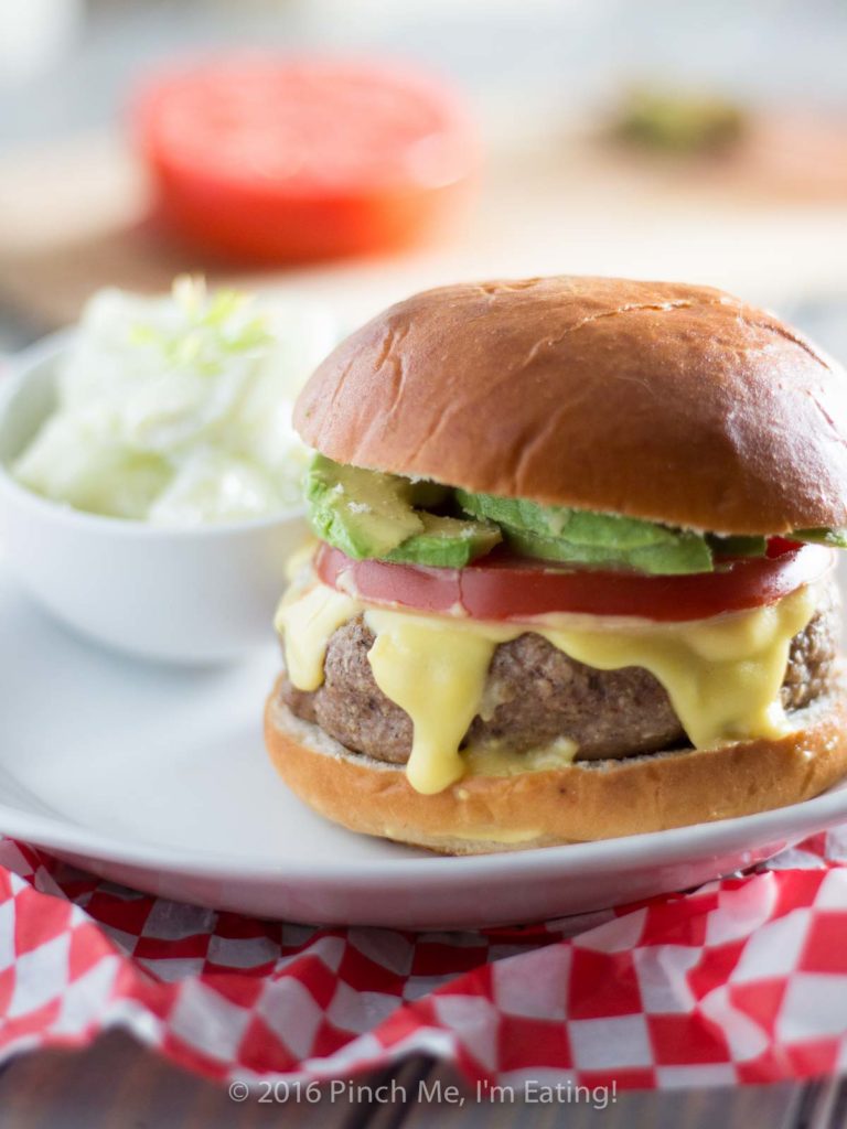 These juicy, aromatic gourmet turkey burgers topped with tomato, avocado, and Hollandaise sauce will make you feel like you're relaxing at an outdoor cafe! | www.pinchmeimeating.com