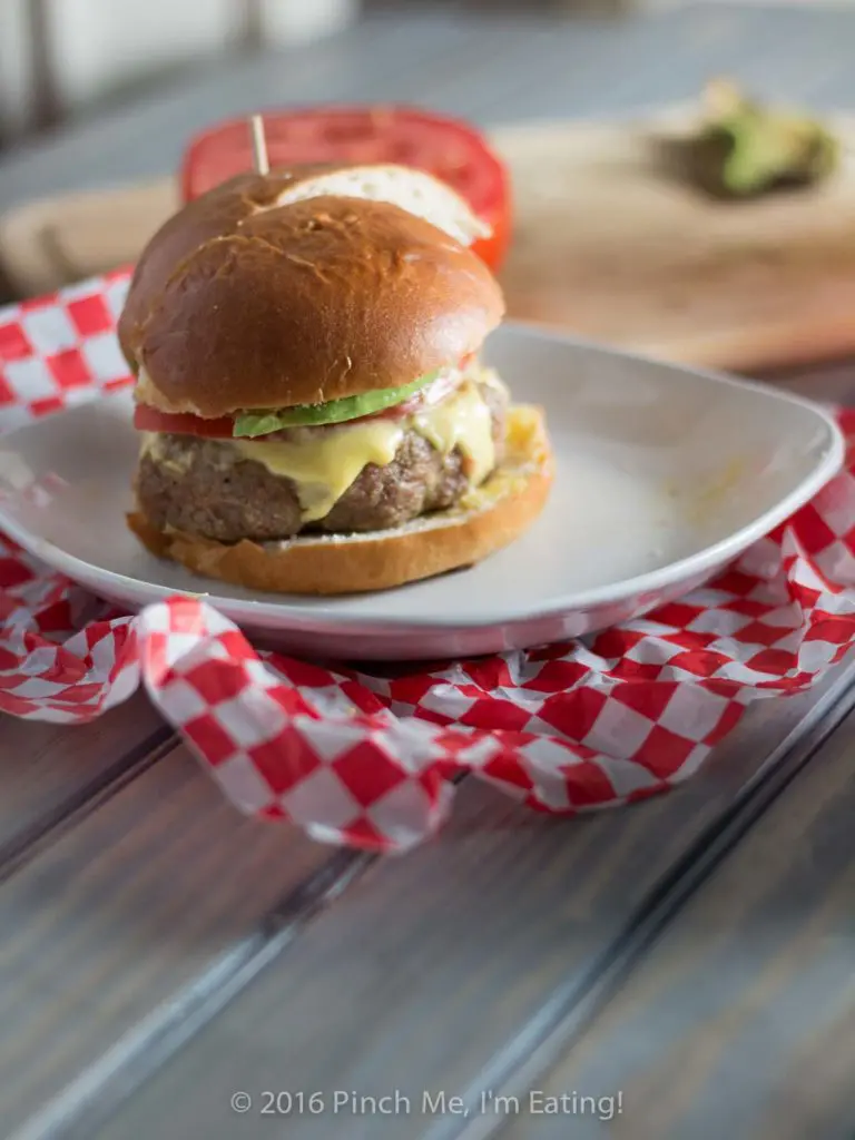 These juicy, aromatic gourmet turkey burgers topped with tomato, avocado, and Hollandaise sauce will make you feel like you're relaxing at an outdoor cafe! | www.pinchmeimeating.com