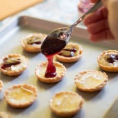 Bite-sized jam and brie tartlets combine melty cheese and your favorite jam for an irresistibly adorable appetizer you can serve at your next wine and cheese party. You'll have a hard time saving some of these canapés for your guests! This recipe uses Brazilian jabuticaba jam, but you can use your favorite kind or even multiple flavors of jam for a variety plate! | www.pinchmeimeating.com