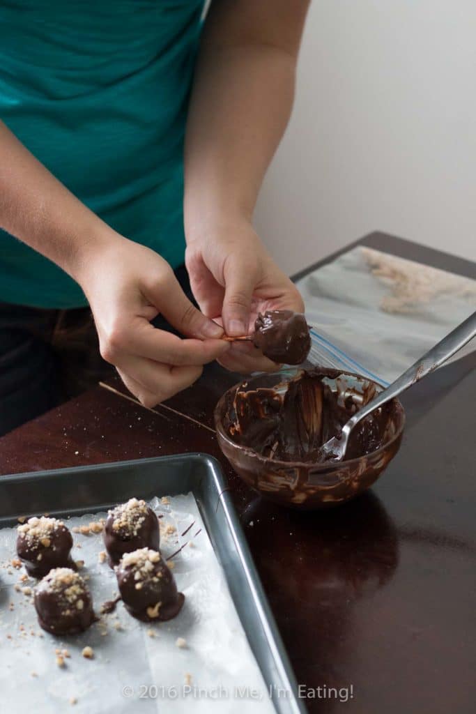 Dipping bonbons in melted chocolate.
