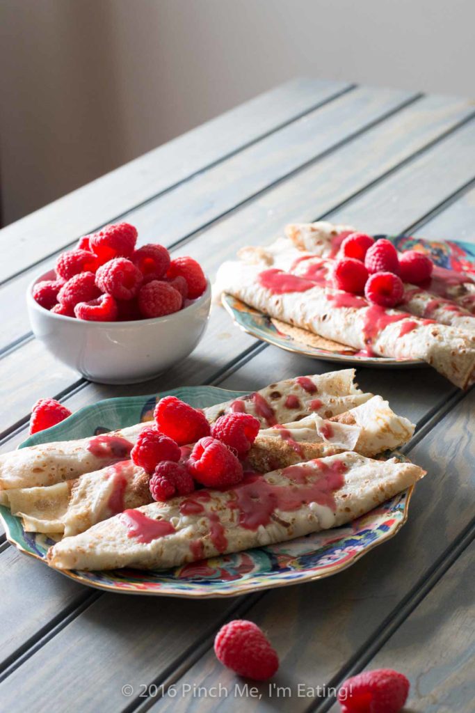 Lemon ricotta crêpes with raspberry sauce make an elegant brunch dish that's easier than it looks, and are a great way to use lemon curd! | www.pinchmeimeating.com