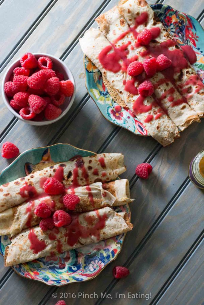 Lemon ricotta crêpes with raspberry sauce make an elegant brunch dish that's easier than it looks, and are a great way to use lemon curd! | www.pinchmeimeating.com