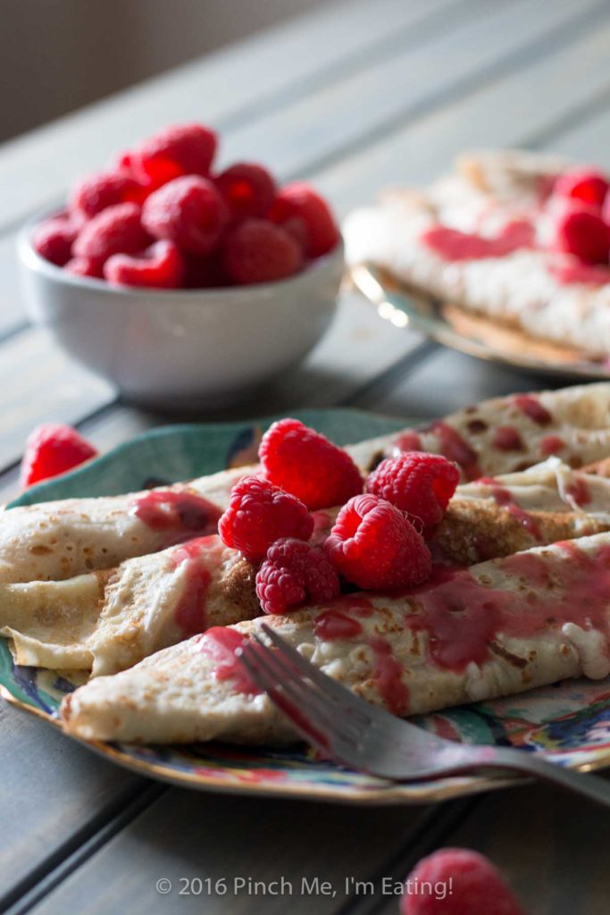 Lemon ricotta crêpes with raspberry sauce make an elegant brunch dish that's easier than it looks, and are a great way to use lemon curd! | www.pinchmeimeating.com
