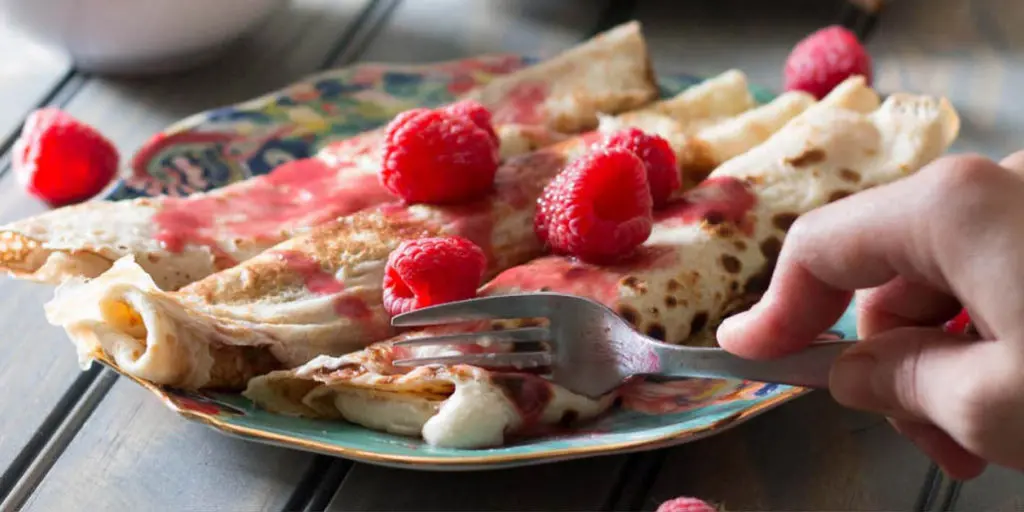 Lemon ricotta crêpes with raspberry sauce make an elegant brunch dish that's easier than it looks, and are a great way to use lemon curd! | www.pinchmeimeating.com