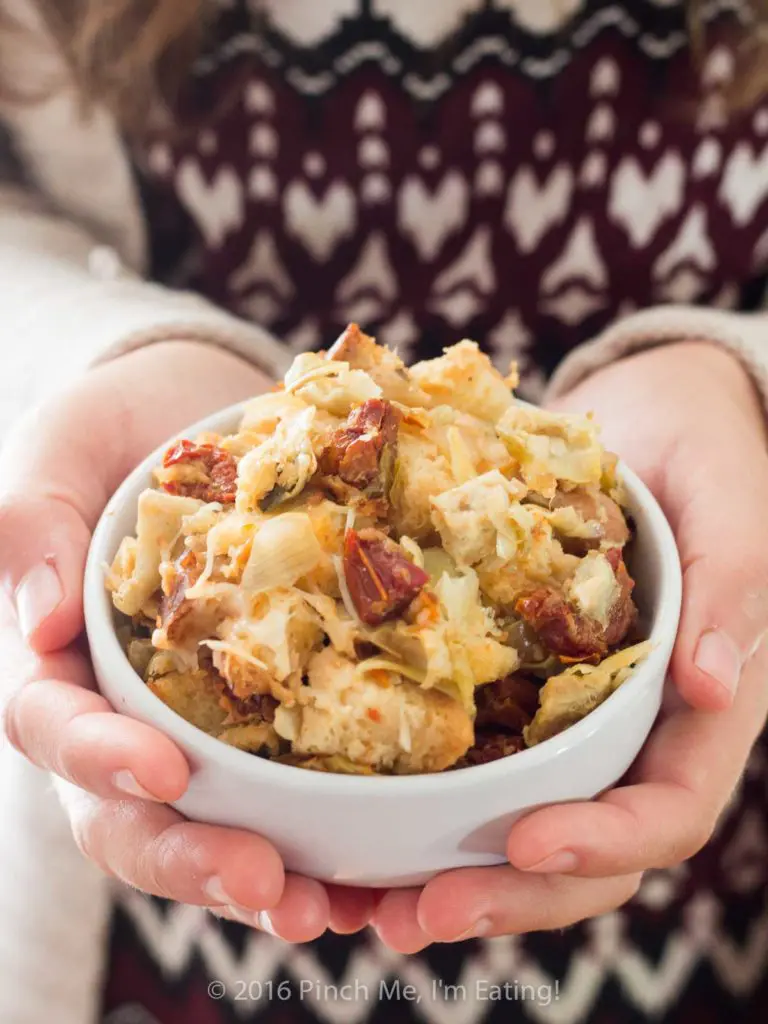 Sourdough sun-dried tomato artichoke stuffing with parmesan is a unique and delicious take on a holiday staple! This recipe is sure to be a crowd-pleaser this Thanksgiving or Christmas! | www.pinchmeimeating.com