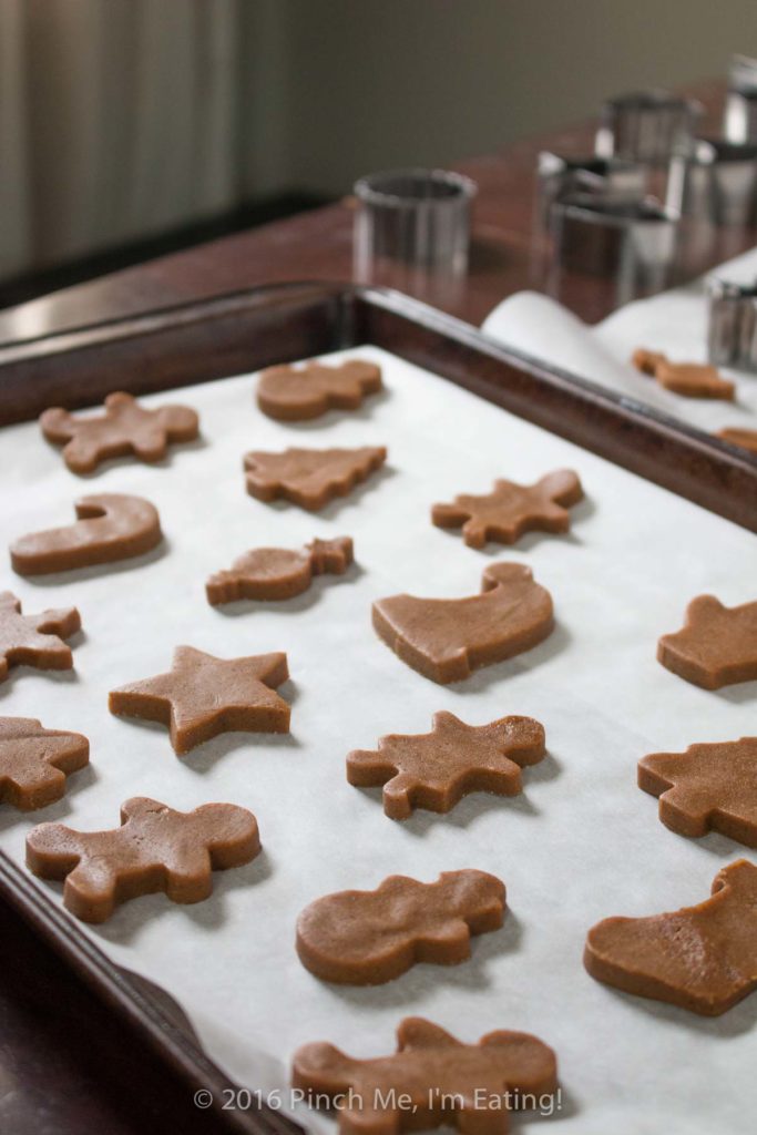 Chewy gingerbread cookies and gingerbread men shapes on baking sheet waiting to be baked