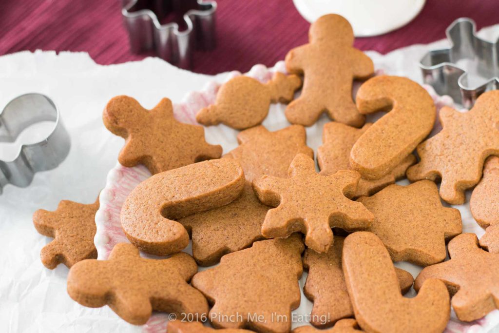 Chewy gingerbread men and other cutout cookies arranged on a plate with cookie cutters