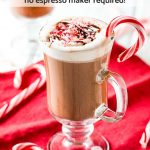 Peppermint mocha in clear mug with candy canes on red napkin