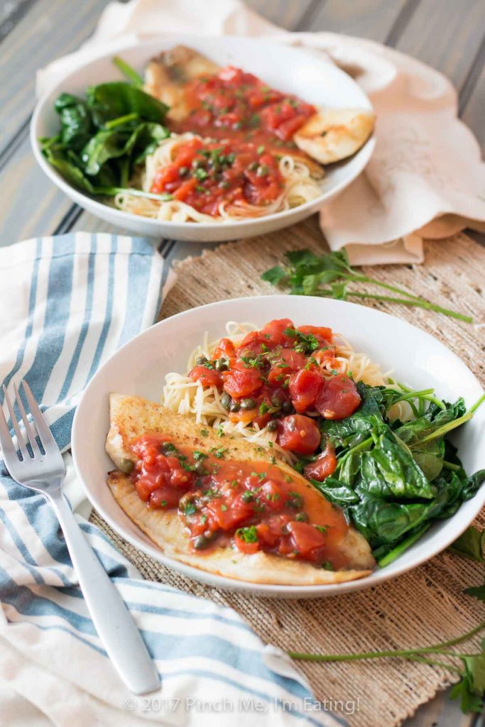 Tilapia with tomatoes and capers is easy to make for a weeknight dinner, healthy, and full of flavor! Serve it with wilted spinach, angel hair pasta, or both.