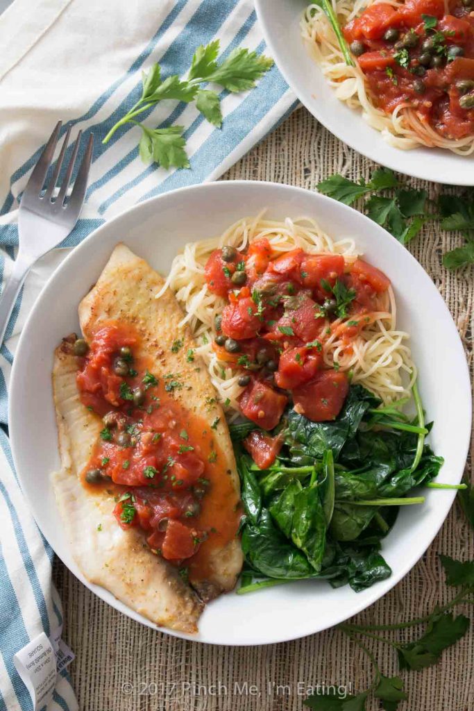 Tilapia with tomatoes and capers is easy to make for a weeknight dinner, healthy, and full of flavor! Serve it with wilted spinach, angel hair pasta, or both.