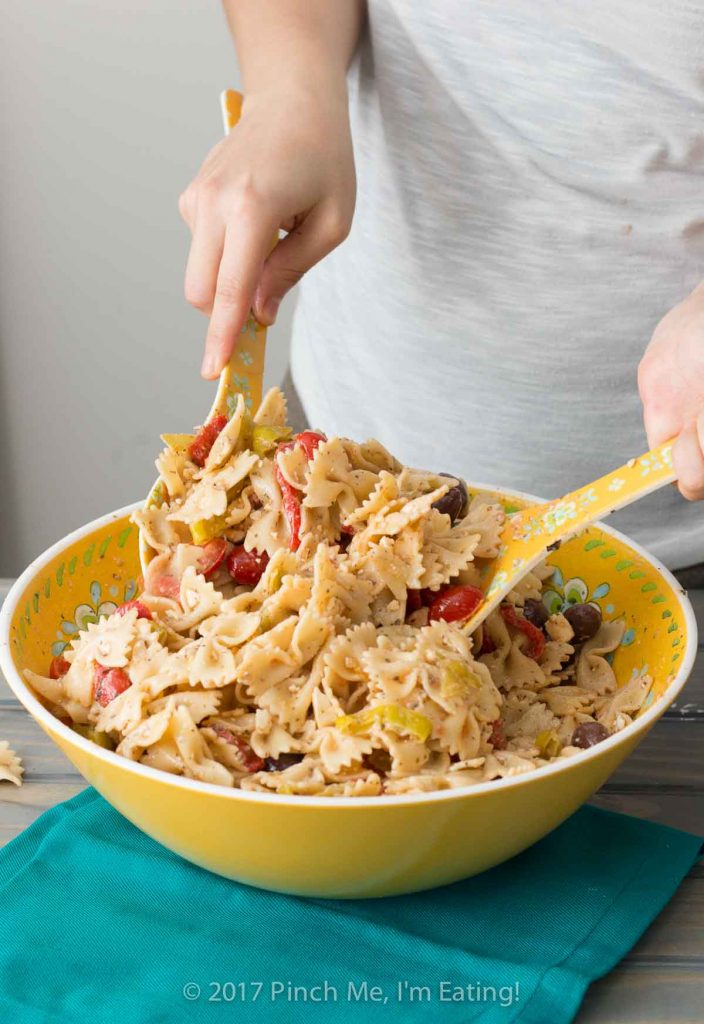 Tossing pasta salad with Greek dressing