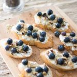 Ricotta crostini with blueberries, walnuts, honey, and thyme is an unexpected and delightful appetizer perfect for serving with wine and cheese!