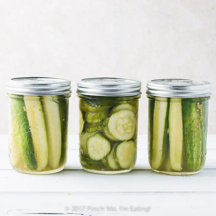 Three closed canning jars of fresh refrigerator dill pickles