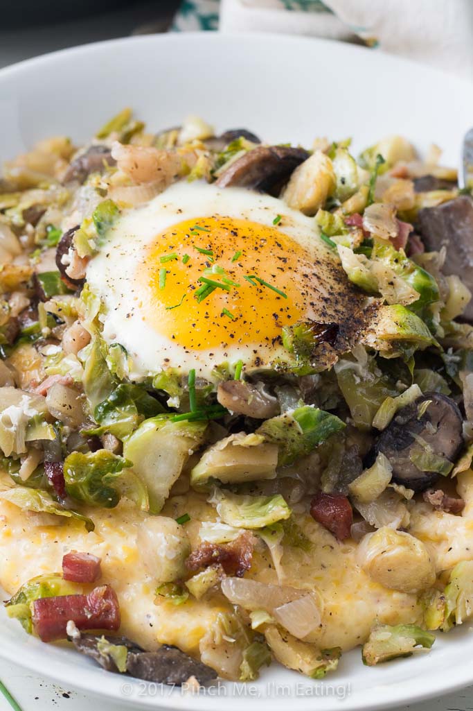 Brussels sprout hash with pancetta, mushrooms, and an egg on top is perfect for breakfast OR dinner, served with cheesy grits!