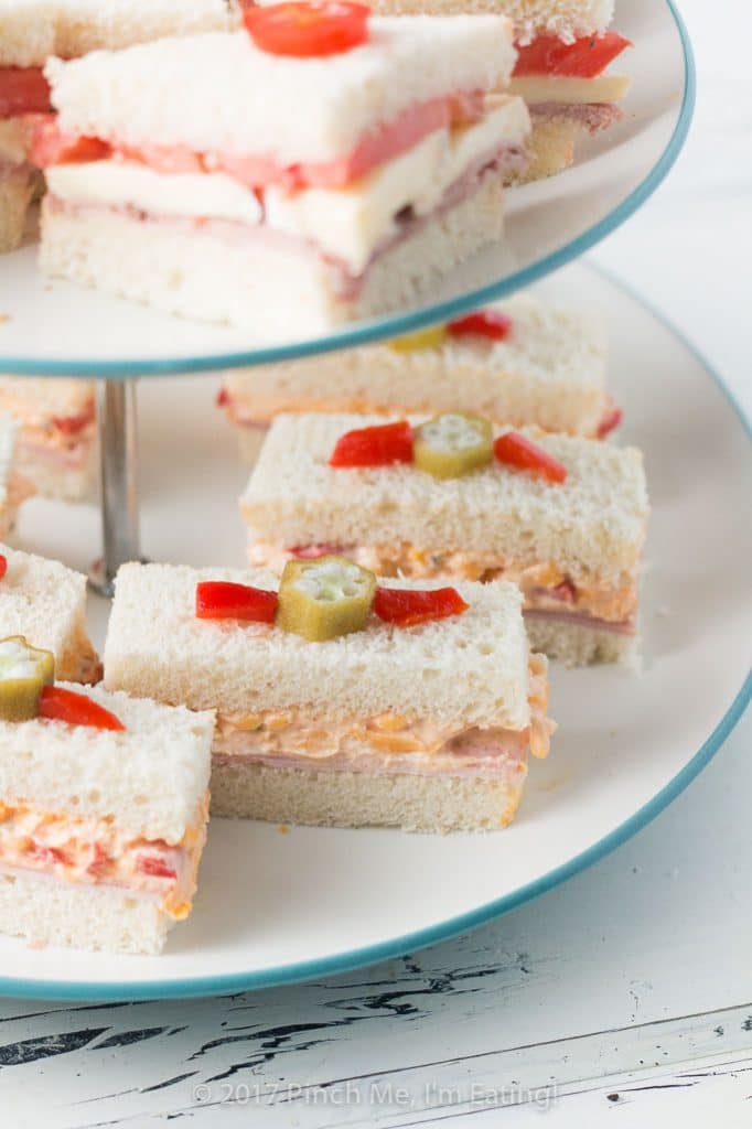 These adorable ham and pimento cheese tea sandwiches would be perfect for a Southern tea party or afternoon tea! And they're topped with the cutest pickled okra garnishes!