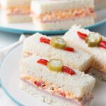 These adorable ham and pimento cheese tea sandwiches would be perfect for a Southern tea party or afternoon tea! And they're topped with the cutest pickled okra garnishes!