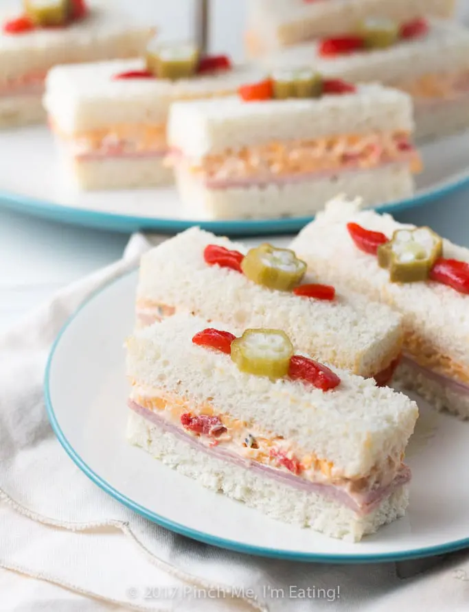 These adorable ham and pimento cheese tea sandwiches would be perfect for a Southern tea party or afternoon tea! And they're topped with the cutest pickled okra garnishes! 