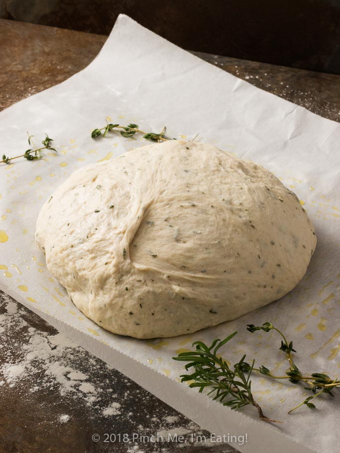 Rosemary thyme no-knead Dutch oven bread is airy and soft on the inside with a glossy crust that shatters when you cut into it - the perfect crusty bread for stew or just dipping into olive oil! Best of all, you hardly have to do anything to make it!