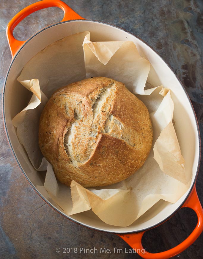 Rosemary thyme no-knead Dutch oven bread is airy and soft on the inside with a glossy crust that shatters when you cut into it - the perfect crusty bread for stew or just dipping into olive oil! Best of all, you hardly have to do anything to make it!