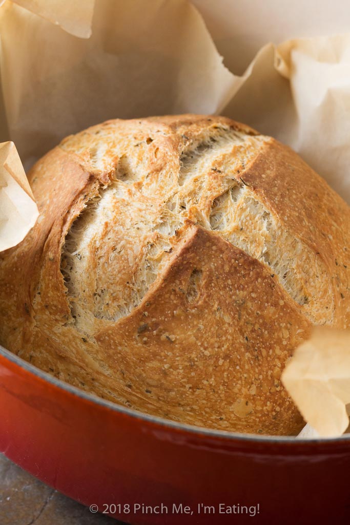 Rosemary thyme no-knead Dutch oven bread is airy and soft on the inside with a glossy crust that shatters when you cut into it - the perfect crusty bread for stew or just dipping into olive oil! Best of all, you hardly have to do anything to make it!