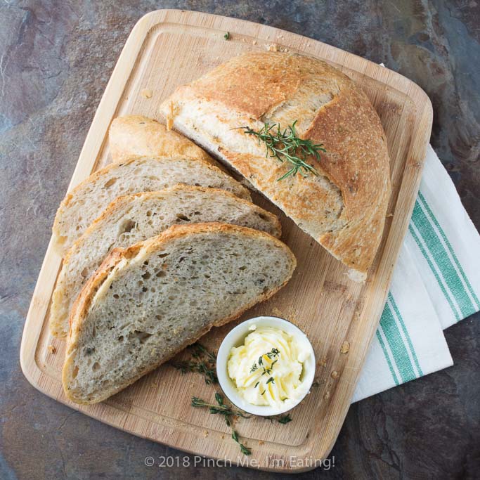 Rosemary thyme no-knead Dutch oven bread is airy and soft on the inside with a glossy crust that shatters when you cut into it - the perfect crusty bread for stew or just dipping into olive oil! Best of all, you hardly have to do anything to make it!