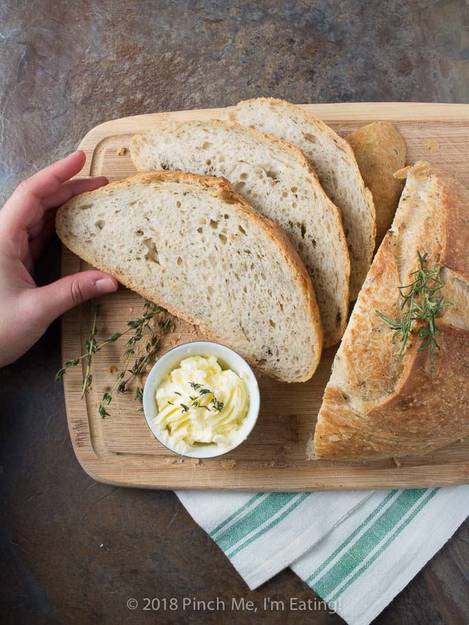 Rosemary thyme no-knead Dutch oven bread is airy and soft on the inside with a glossy crust that shatters when you cut into it - the perfect crusty bread for stew or just dipping into olive oil! Best of all, you hardly have to do anything to make it!