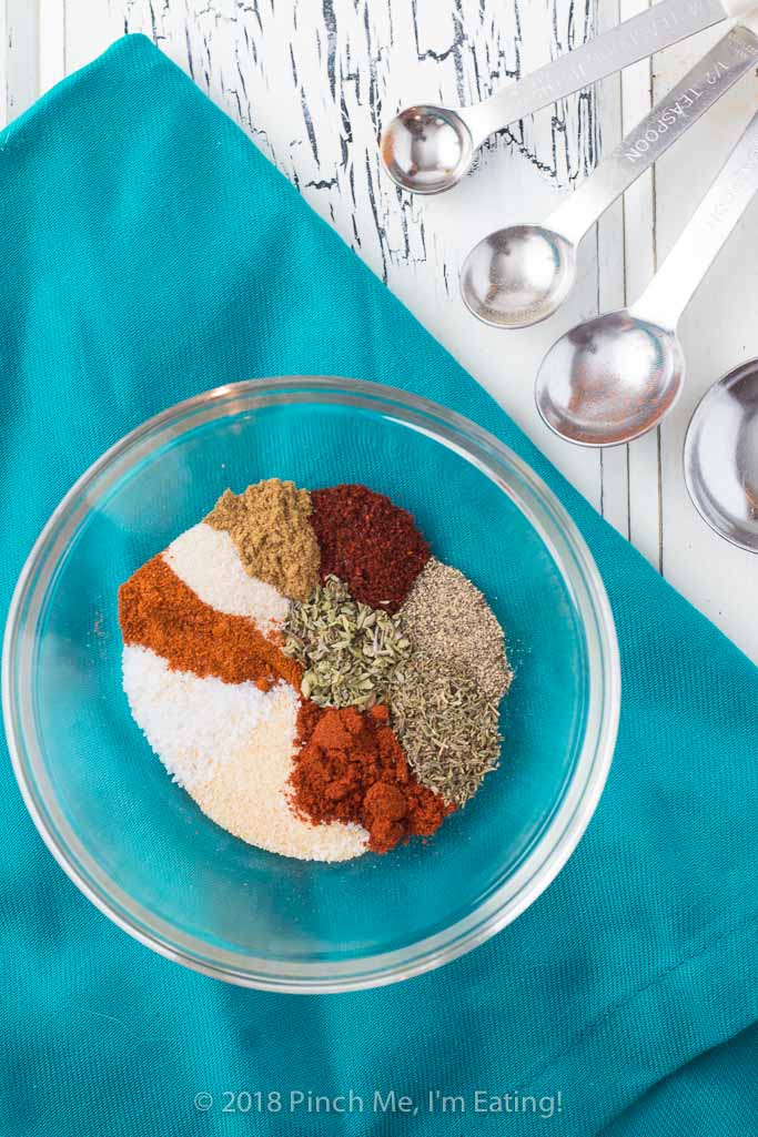 Overhead shot of blackening seasoning spices in glass bowl on blue napkin