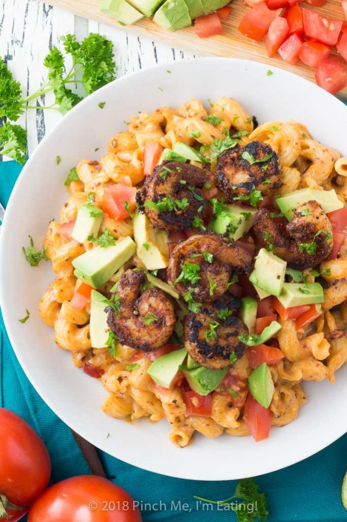 Overhead shot of chipotle mac and cheese with blackened shrimp in white bowl