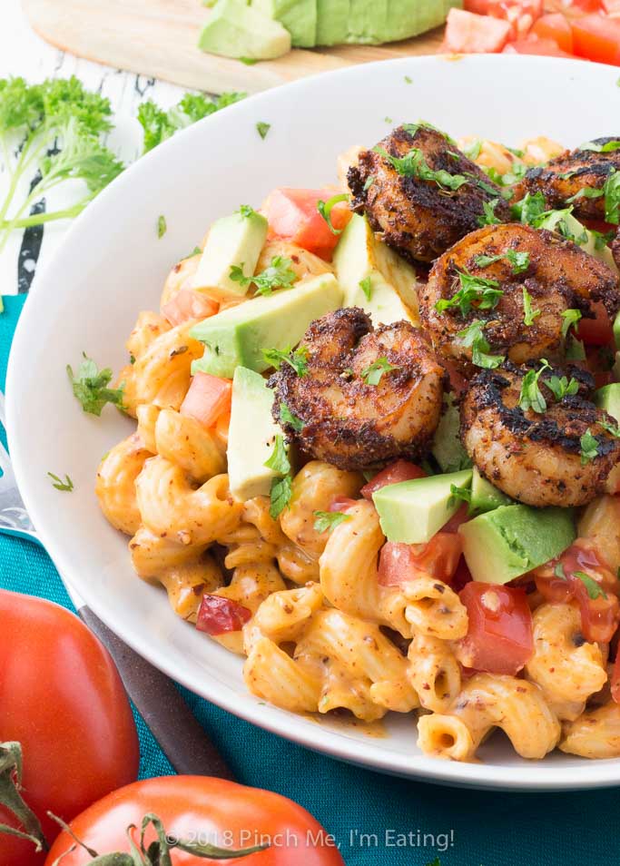 Three-quarter shot of chipotle mac and cheese with blackened shrimp in white bowl