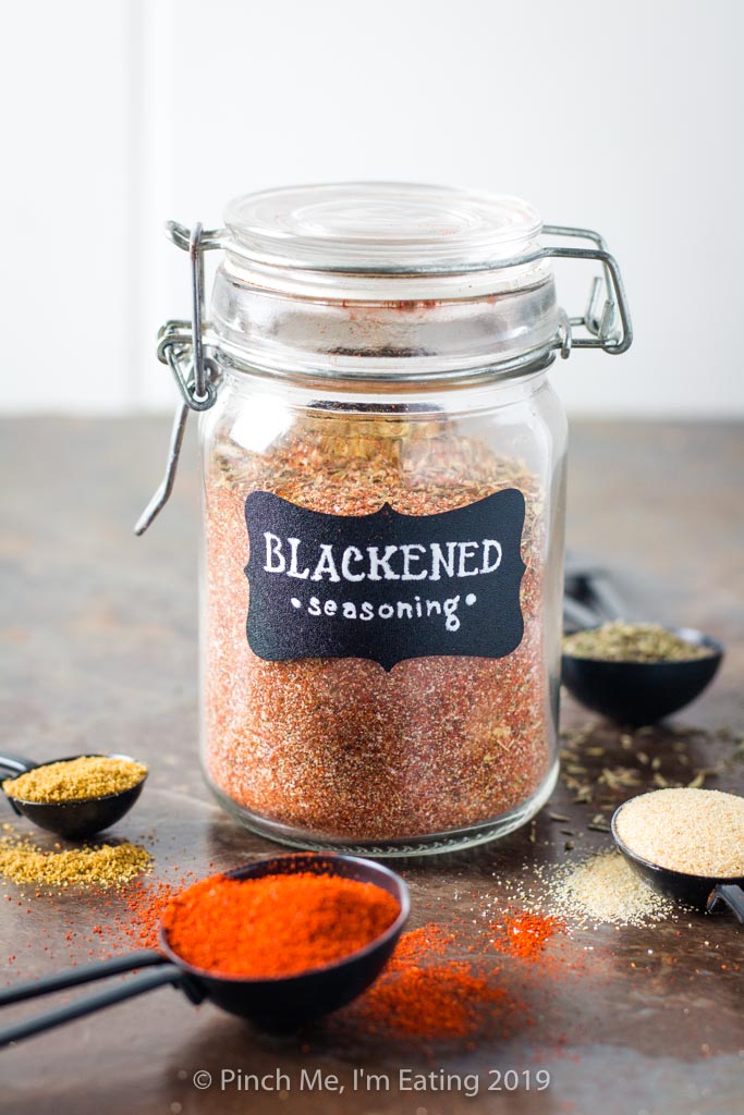 Blackened seasoning in glass spice jar surrounded by spices