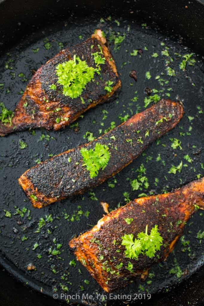 Overhead shot of blackened salmon in a cast iron skillet