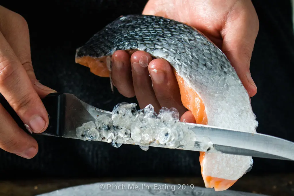 Process shot of descaling salmon fillets