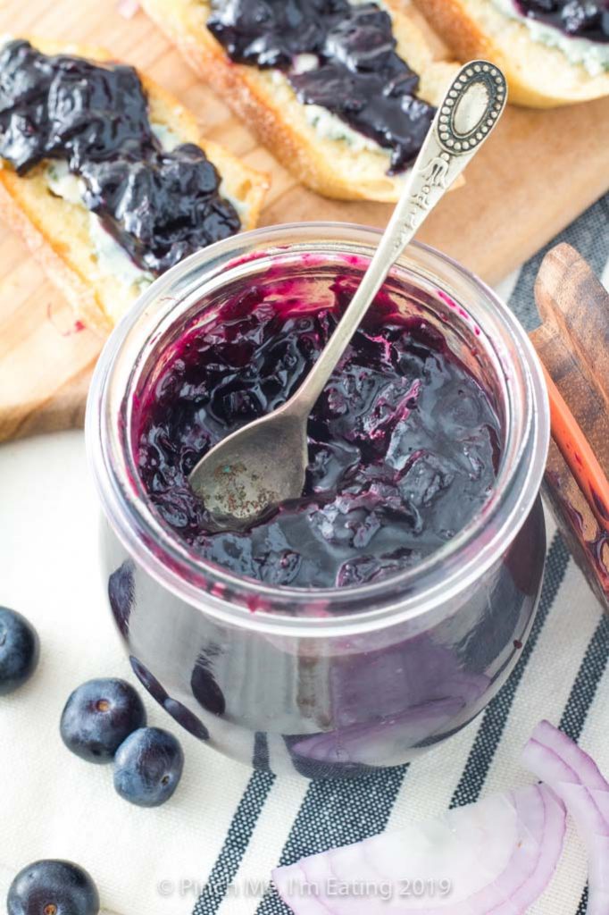 Sweet and savory blueberry and caramelized red onion jam recipe in jar with spoon