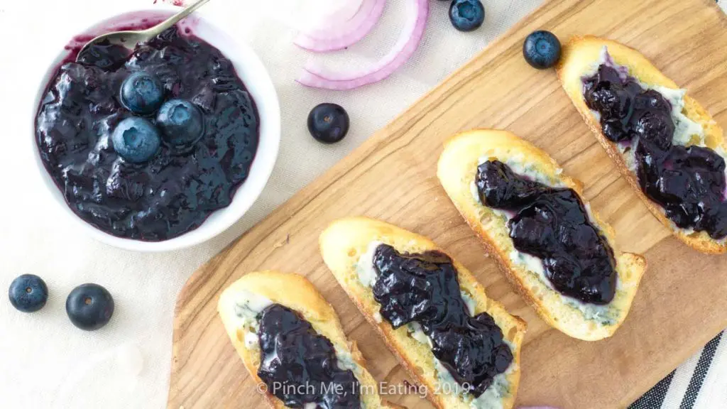 Overhead shot of sweet and savory blueberry and caramelized red onion jam on crostini