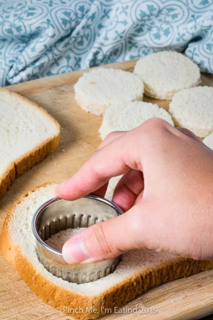 Cutting bread with a cookie cutter for tea sandwiches