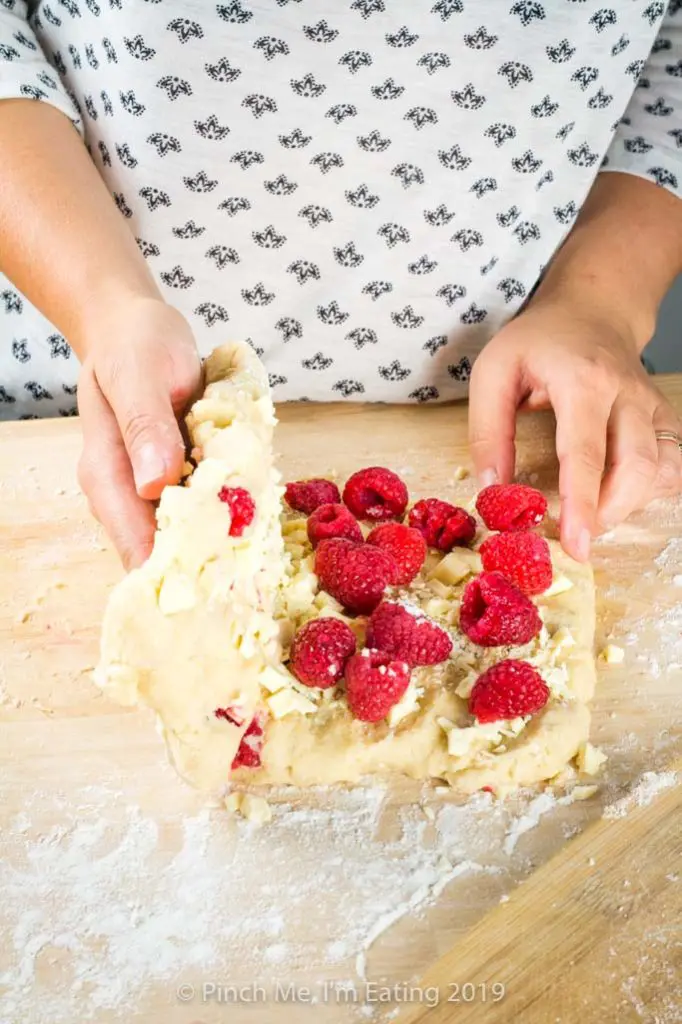 Folding white chocolate and raspberries into scone dough