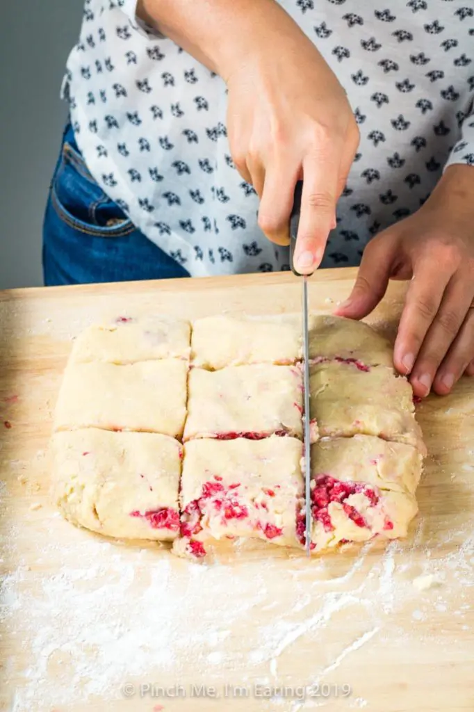 Cutting dough for white chocolate raspberry scones